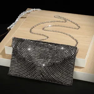 Elegante borsa da sera a bustina con paillettes nere e tracolla a catena argentata.