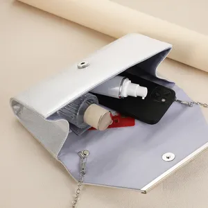 Detail view of silver evening clutch bag showing spacious interior and daily storage capacity.