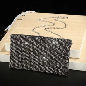 Vista dettagliata della pochette da sera nera e scintillante con texture di paillettes.