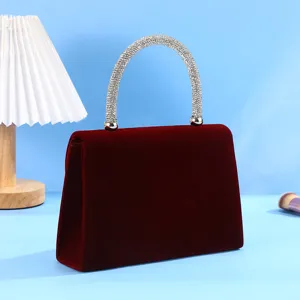 Elegant red velvet evening bag featuring a sparkling rhinestone handle for party and wedding dress.