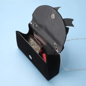 Elegant black velvet evening bag with bow design, silver chain strap, perfect for parties.