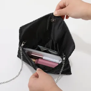 Borsa da sera nera di perline dettaglio che mostra scomparti interni e la tracolla.