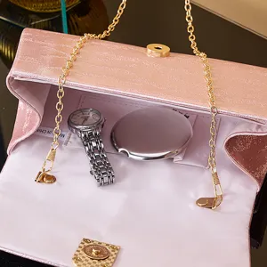 Pink PU leather evening bag detail, elegant gold chain strap and compact interior with watch.