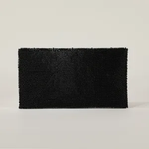 Vista dettagliata della borsa pochette da sera nera perlata, design strutturato elegante.