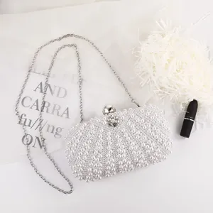 Pearl clutch bag detail closeup showing intricate beading texture, elegant chain strap and clasp.