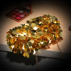 Borsa da sera dorata con paillettes, dettaglio con catena in metallo e chiusura.
