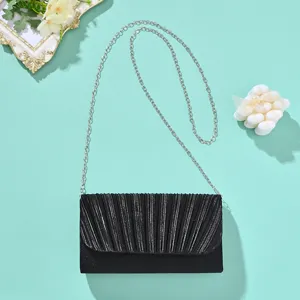 Black pleated evening clutch bag with silver chain strap, elegant accessory detail shot.