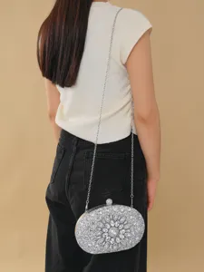Detailed view of a sparkling silver rhinestone evening clutch bag with delicate metal chain.