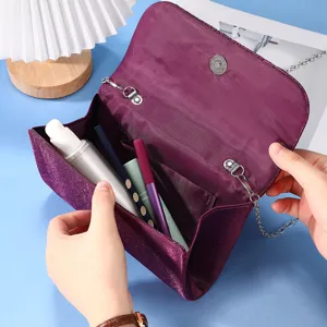 Elegant purple evening clutch bag interior detail, featuring spacious compartment and chain.