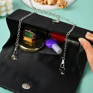 Black glitter evening bag detail showcasing interior capacity, silver chain and design.