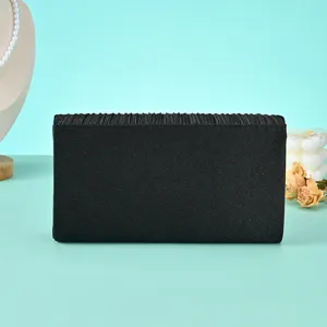 Detailed view of a black pleated evening clutch bag, elegant texture for special events.