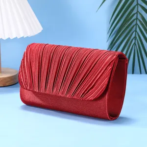 Detailed view of the elegant red pleated evening clutch bag, highlighting its fine texture.