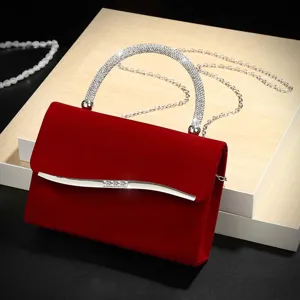 Red velvet evening bag detail, rhinestone handle and metal magnetic clasp for women.