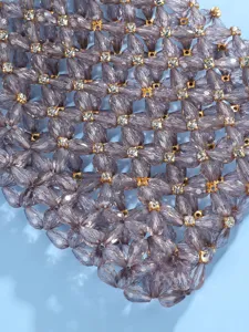 Close-up detail of beaded evening handbag, sparkling rhinestone and purple teardrop crystal mesh.