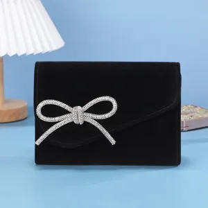Detailansicht der schwarzen Abendtasche mit glänzender Strass-Schleife, elegant und luxuriös.