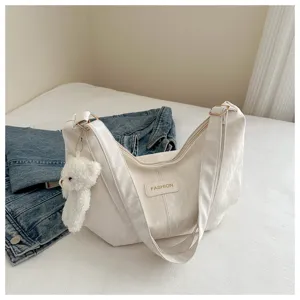 Primer plano de un bolso blanco casual con un lindo colgante de peluche y bonito diseño.