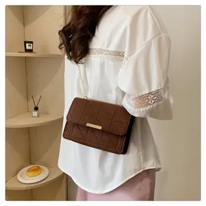 Bolso bandolera de fieltro marrón con cadena dorada y cierre metálico para un look elegante.