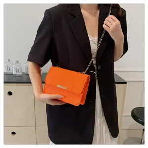 Bolso bandolera acolchado naranja con cadena dorada, elegante vista detallada para uso diario.