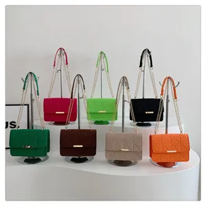 Detalle de bolso bandolera cadena fieltro color caramelo, bolso pequeño elegante mujer.