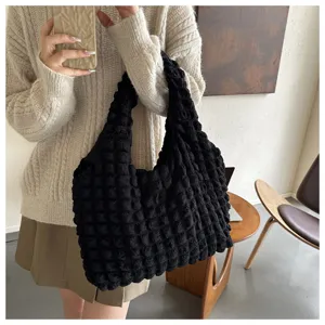 Black textured bubble shoulder bag detail showing the unique puckered fabric and stylish design.