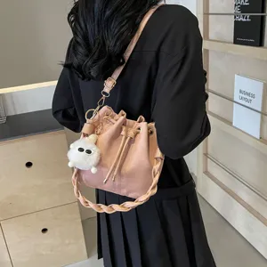 Bolso tipo cubo rosa chic con asa trenzada y bonito colgante esponjoso para uso diario elegante.