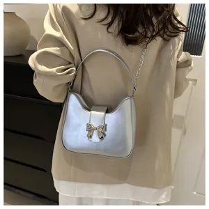 Zilveren schoudertas voor dames, trendy handtas met metalen strikdetail en elegant design.