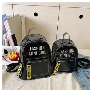 Vista detallada del conjunto de minimochilas de charol negro con estampado de letras.