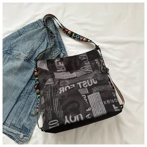 Black casual Oxford cloth bucket backpack with newspaper print and colorful letter straps.