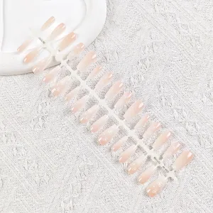 Set de uñas postizas nude degradadas con bonito estampado de lazo blanco para manicura.