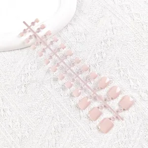 Vista detallada de uñas postizas de los pies en rosa nude sobre una tira de plástico.