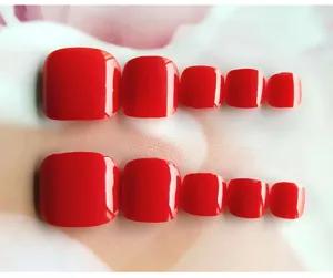 Close-up van glanzende felrode neppe teennagels, korte vierkante nageltips details.