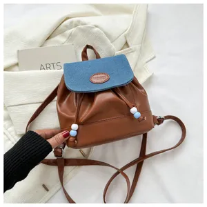 Sac à dos mini tendance avec rabat en jean et cuir PU, design bicolor et détails de perles chic.
