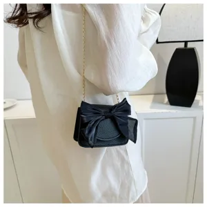 Chic black crossbody bag featuring a sheer bow and gold chain strap for stylish daily wear.