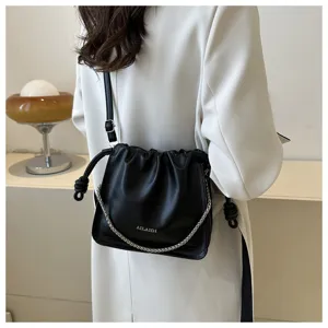 Vista dettagliata della borsa a spalla nera plissettata con catena e coulisse alla moda.