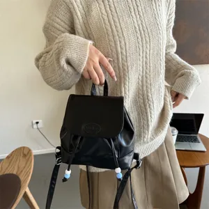 Petit sac à dos femme en cuir noir élégant avec perles colorées et fermeture à cordon tendance.
