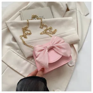 Pink mini shoulder handbag with a big organza bow and luxury gold chain strap for stylish women.