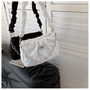 Detail view of trendy pleated shoulder bags featuring soft fabric and chic metal chain decoration.
