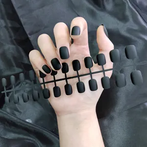 Matte zwarte korte ronde neppe nagels in gedetailleerd overzicht, gladde en elegante afwerking.