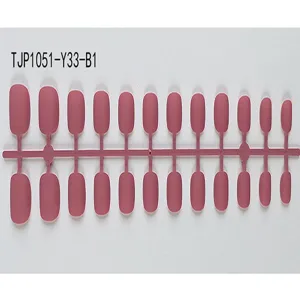 Close-up van matte roze korte ronde kunstnagels op plastic houder detailweergave.