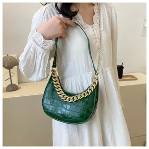 Vista detallada del bolso hobo verde con motivo de cocodrilo y elegante cadena de estrás.