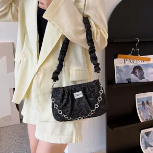 Stylish black crinkled shoulder bag for women featuring a chic flower chain and pleated strap.
