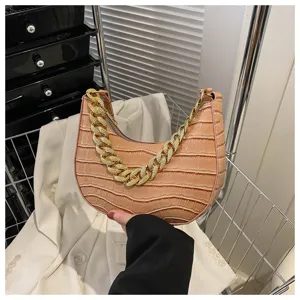 Detalle bolso de hombro cocodrilo, elegante asa de cadena dorada, bolso elegante.