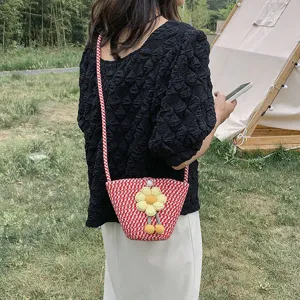 Summer woven mini bucket bag with cute flower charm, stylish red white crossbody design.