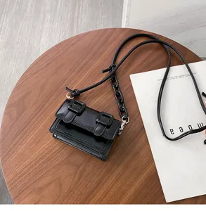 Stylish mini black crossbody shoulder bag with chic chain strap and double buckle closure detail.