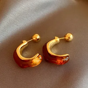 Retro brown resin geometric gold-plated earrings detail view, elegant niche design style.