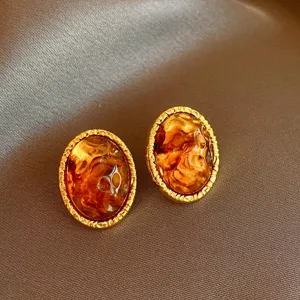 Vintage brown resin oval stud earrings with golden textured border for women elegant jewelry.