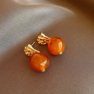 Detailed close-up view of retro brown resin and gold-plated geometric earrings design.