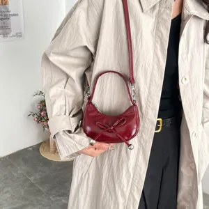 Élégant sac porté épaule croissant en cuir verni avec nœud mignon et poignée pour femmes mode.