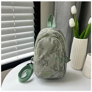 Vista dettagliata della borsa da petto in tela verde chiaro con stampa orsetto carino.
