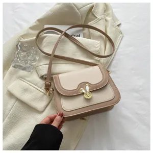 Chic contrast color crossbody bag detail featuring elegant beige design with cute metal lock.